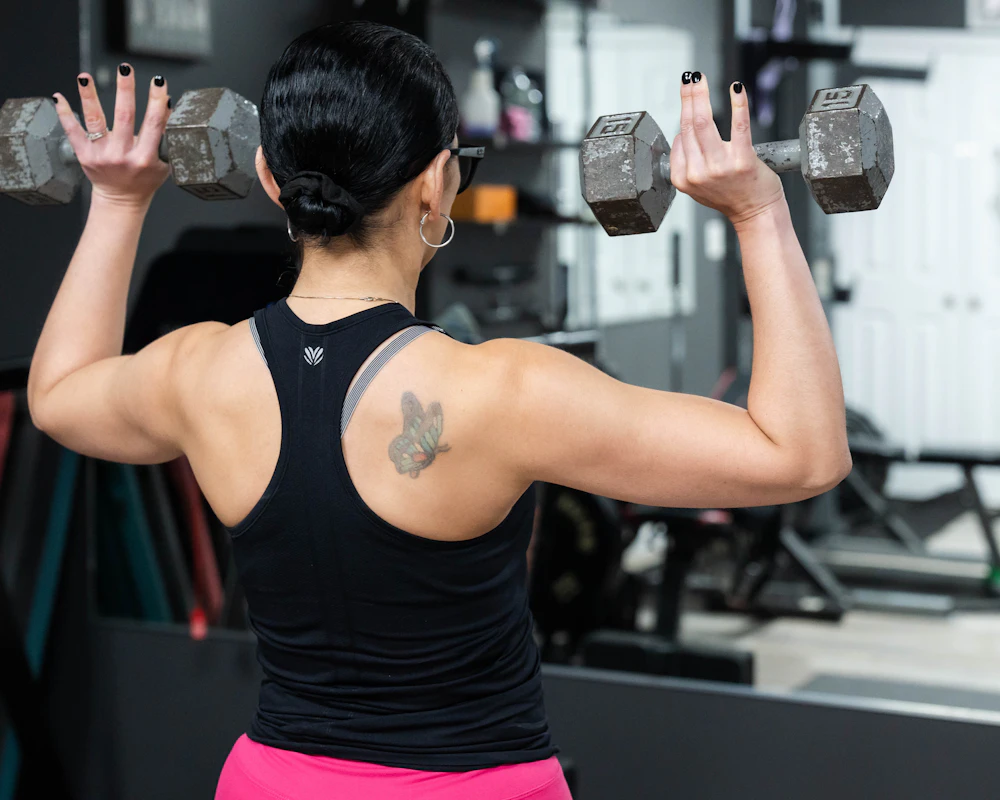 A strong woman lifting dumbbells overhead