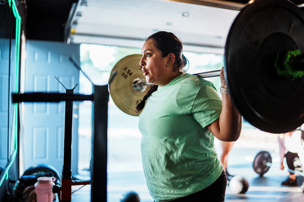 A woman lifting a barbell in a home gym